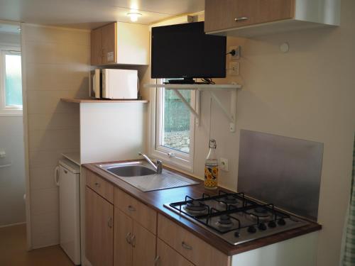 a small kitchen with a stove and a sink at LE CASQUE ROI in Salavas
