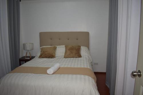 1 dormitorio con 1 cama grande y cabecero blanco en Affordable Makati APT, en Manila