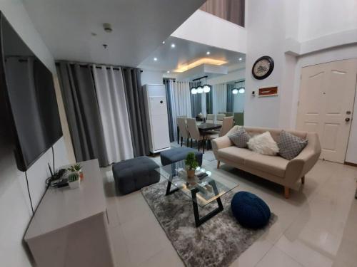 a living room with a couch and a tv at Affordable Makati APT in Manila