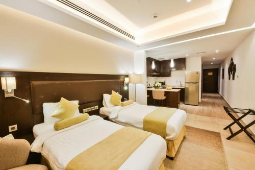 a hotel room with two beds and a kitchen at Downtown Hotel Apartments in Amman