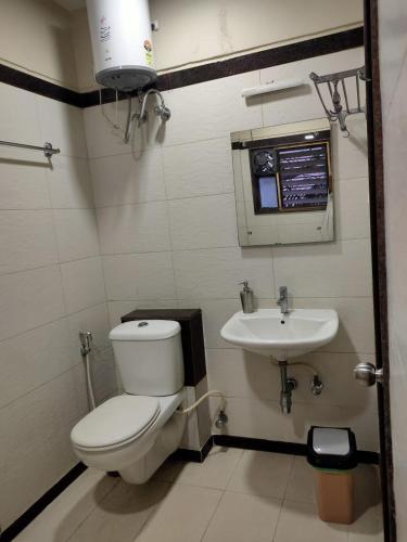 a bathroom with a toilet and a sink at Hotel Rose Mansion Manyata Tech Park in Bangalore