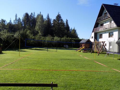 a large yard with a playground with nets and a building at Pokoje u Teresy in Czarna Góra