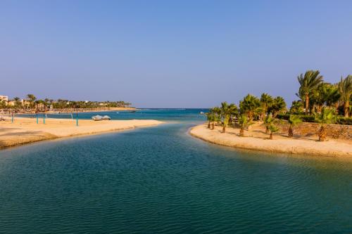 a body of water with palm trees on a beach at Brayka Bay Reef Resort in Abu Dabab