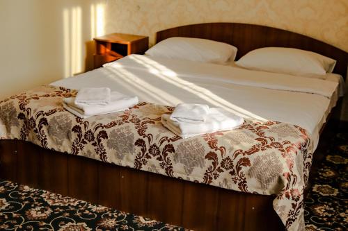 a bedroom with a bed with two towels on it at Hotel LaMa 2 in Kyiv