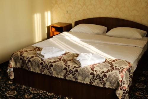 a bedroom with a bed with two towels on it at Hotel LaMa 2 in Kyiv