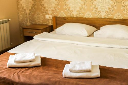 a bed with two towels on top of it at Hotel LaMa 2 in Kyiv