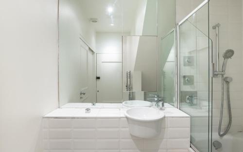 a white bathroom with a sink and a shower at The Notting Hill Escape - Modern & Bright 3BDR Flat with Balcony in London