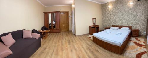 a bedroom with a bed and a couch in it at Hotel LaMa 2 in Kyiv