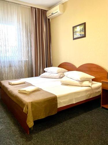 a bedroom with a bed with white sheets and a window at Hotel LaMa 2 in Kyiv