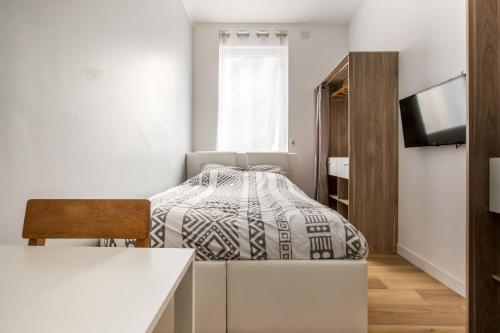 a small bedroom with a bed and a tv at Grand appartement avec 3 salles de bain in Tourcoing