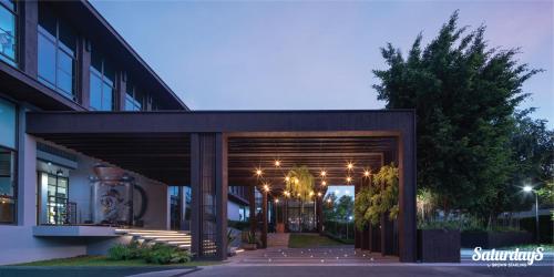 a building with a wooden entrance with lights on it at Saturdays Residence by Brown Starling in Rawai Beach