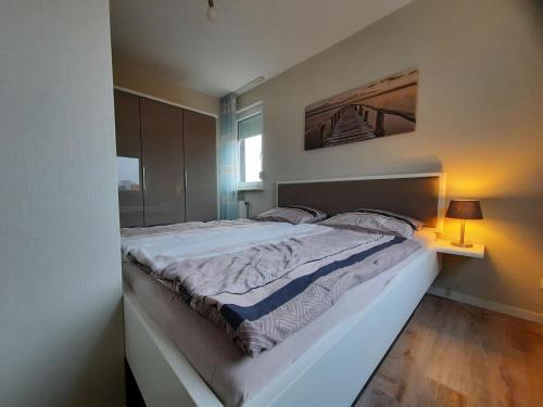 ein Schlafzimmer mit einem großen Bett mit einem Bild an der Wand in der Unterkunft Haus am Deich Wohnung 14 in Dahme