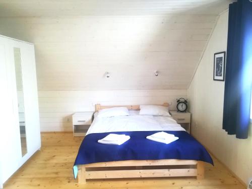 a bedroom with a bed with two towels on it at OSADA NA WYSPIE in Gdańsk