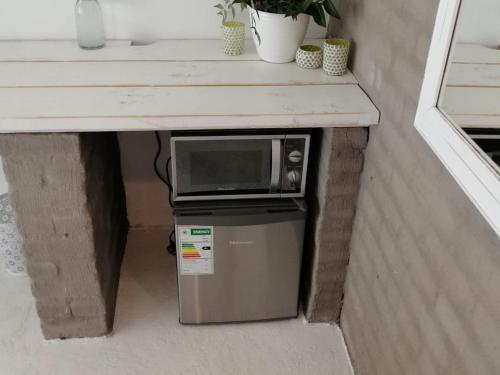 a microwave sitting on top of a refrigerator under a counter at The Last Eve Guesthouse in Douglas