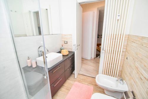 La salle de bains est pourvue d'un lavabo, de toilettes et d'un miroir. dans l'établissement SARA E MELISSA HOUSE LIERNA, à Lierna