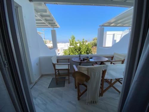 a balcony with a table and chairs and a view of the ocean at CAELI PAROS by Kostas & Joanna Studios in Logaras