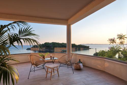 a balcony with a table and chairs and a view of the ocean at Prima Vista Boutique Hotel & Spa in Sivota