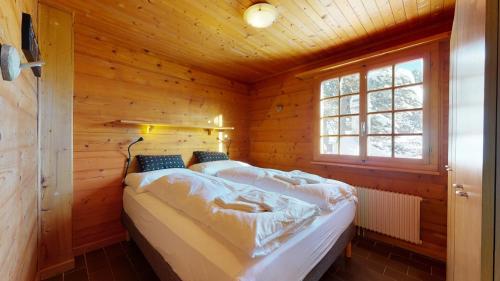 um quarto com duas camas em uma cabana de madeira em Apartment at the bottom of the slopes in Crans-Montana, cosy atmosphere em Crans-Montana