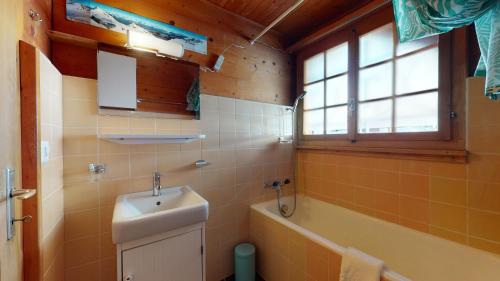 y baño con lavabo y bañera. en Apartment at the bottom of the slopes in Crans-Montana, cosy atmosphere en Crans-Montana