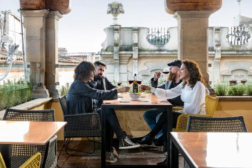 a group of people sitting at a table in a restaurant at Cal Roure Boutique Hotel in Igualada