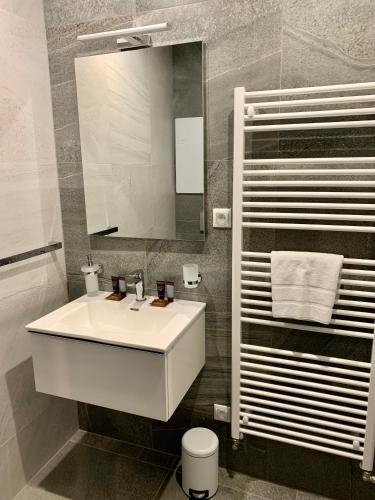 a bathroom with a white sink and a mirror at Apartmány Tatry in Smokovce