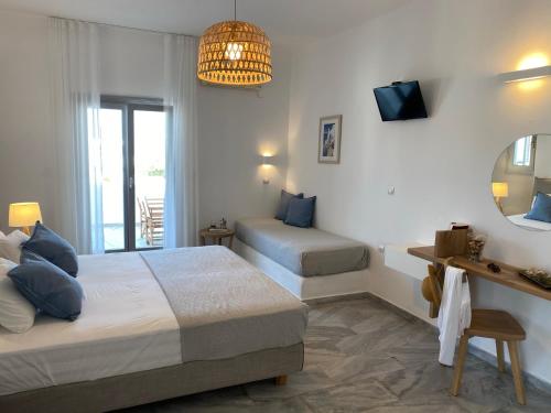 a bedroom with two beds and a mirror at Kostas & Joanna Studios in Logaras