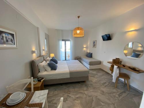 a bedroom with a bed and a table and a mirror at CAELI PAROS by Kostas & Joanna Studios in Logaras