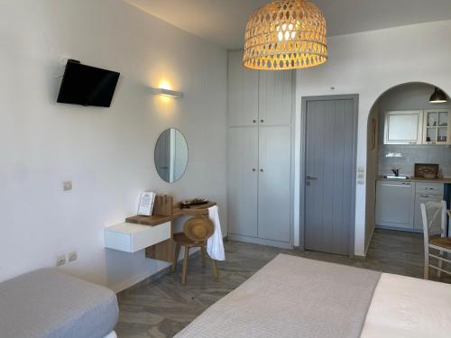 a bedroom with a bed and a desk with a mirror at CAELI PAROS by Kostas & Joanna Studios in Logaras