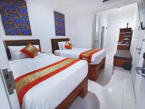 a hotel room with two beds and a piano at Arawa Traveller's Inn Motel in Makassar
