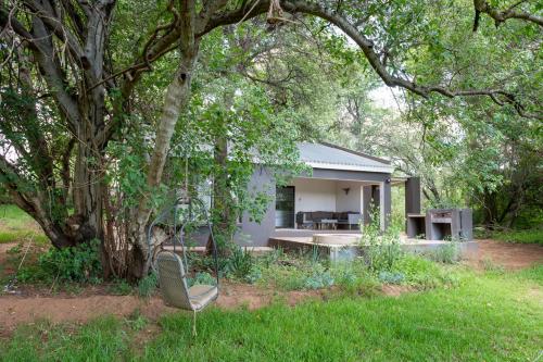 a white house with a chair in the yard at Bushriver Lodge in Mica