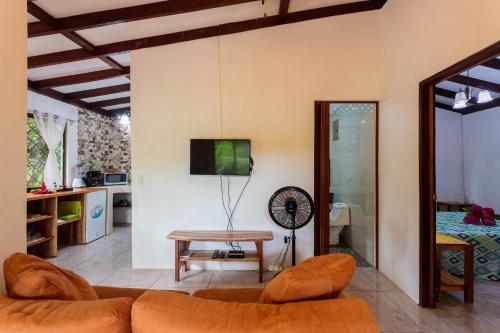 a living room with a couch and a table at Bungalows Ache Cozy House in Cahuita