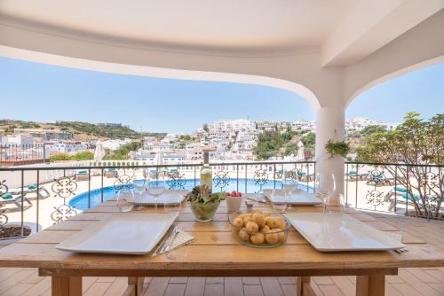 a table on a balcony with a view of the city at Bertolina Guest House in Albufeira