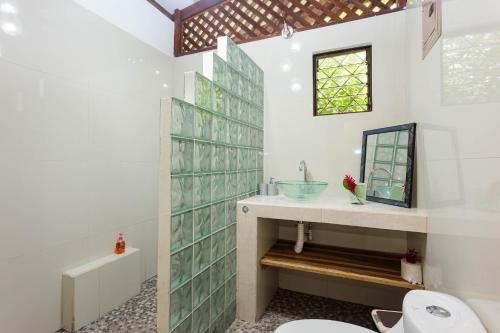 a bathroom with a sink and a toilet at Bungalows Ache Cozy House in Cahuita