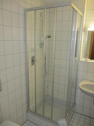 a shower with a glass door in a bathroom at Sontheimer Wirtshäusle in Sontheim im Stubental