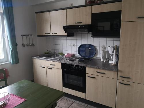 a kitchen with wooden cabinets and a stove top oven at Das Landhaus am Haff LHH B06 in Stolpe