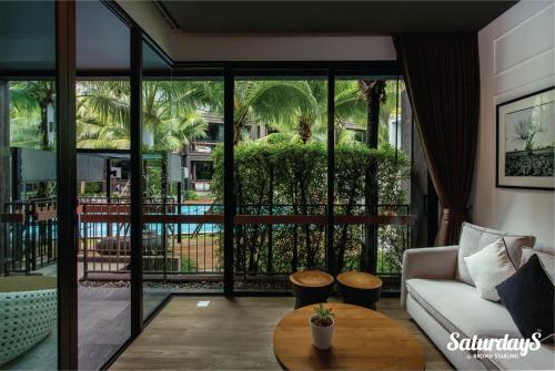 a living room with a couch and a table at Saturdays Residence by Brown Starling in Rawai Beach
