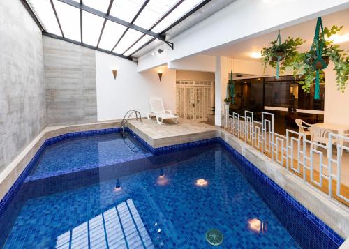 a swimming pool in a house with a table and chairs at H Hotel in Balneário Camboriú