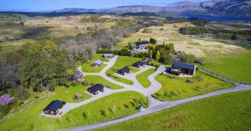 an aerial view of a house on a hill with a road at Airdeny Chalets in Taynuilt