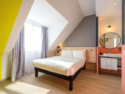 una camera con letto, specchio e lavandino di ibis Styles Wien Messe Prater a Vienna