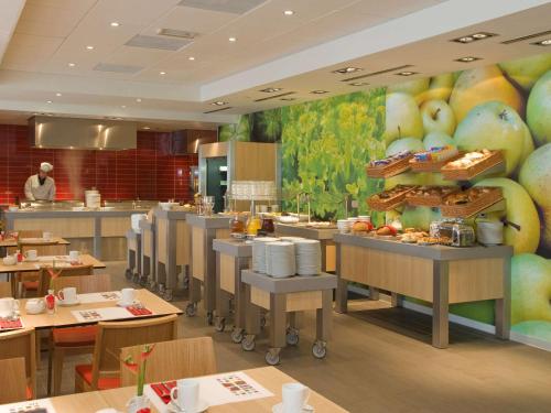 a restaurant with a large mural of fruit on the wall at Mercure Hotel Den Haag Central in The Hague