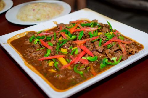 a plate of food with meat and vegetables on a table at Dovenest Lodge in Naivasha