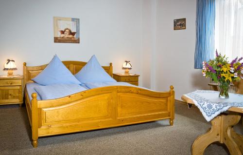 a bedroom with a wooden bed with blue pillows at Zum Kirchenwirt in Lam