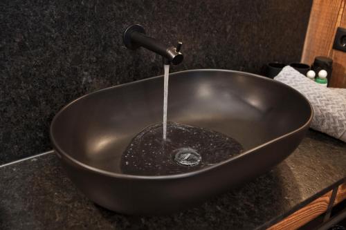 a black bowl sink with water pouring into it at Villa Michaela in Gerlos