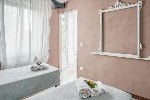 a room with two beds with towels and a mirror at Villa Curte Nicia in Nizza Monferrato