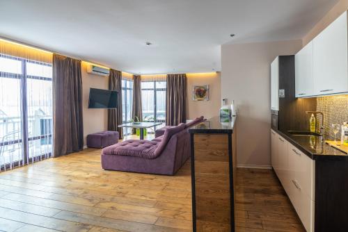 a living room with a purple couch and a table at F&B Spa Resort (ex. Fomich Hotel) in Bukovel