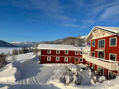 un edificio rosso nella neve con terreno ricoperto di neve di Hotell Karolinen Åre a Åre