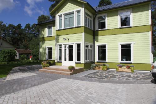 a green and white house with a driveway at Mere 38 Apartments in Võsu