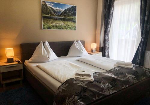 a bedroom with a large bed with a window at Hotel Mallnitz in Mallnitz