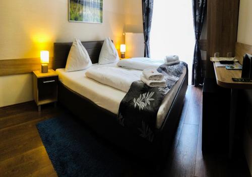 a hotel room with a bed with towels on it at Hotel Mallnitz in Mallnitz