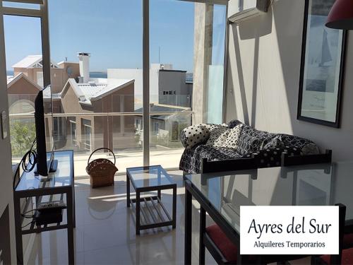 a room with a bed and a table and a window at Ayres del Sur in Puerto Madryn